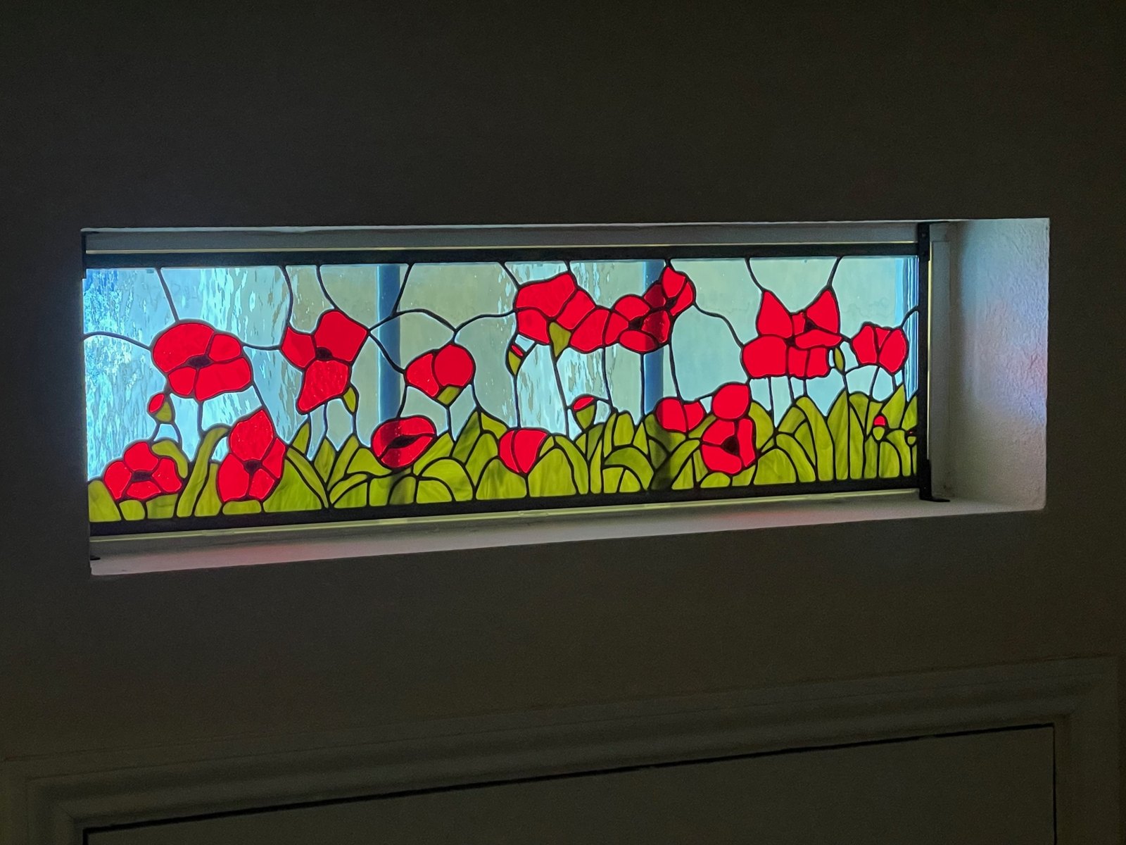 A custom stained glass window featuring red poppies